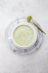 Matcha latte drink in mug on marble background
