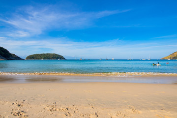Fototapeta na wymiar beautiful sea curve sand beach with green trees on the moutain