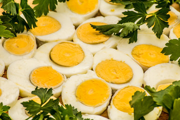 Boiled eggs cut in halves decorated with fresh parsley leaves