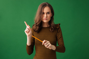 Serious young woman looking camera holding pencil.