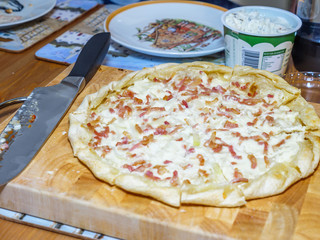 Close-up Of Whole Pizza on wooden board on table
