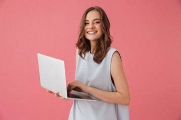 Naklejka premium Cheerful young woman using laptop computer. Looking camera.