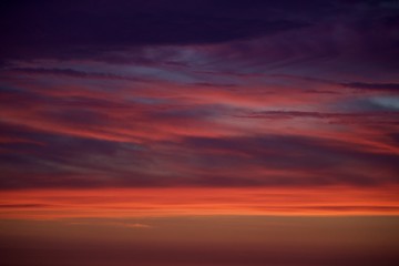 Nuvens vermelhas com o reflexo do sol ao fim da tarde. Pôr-do-sol.