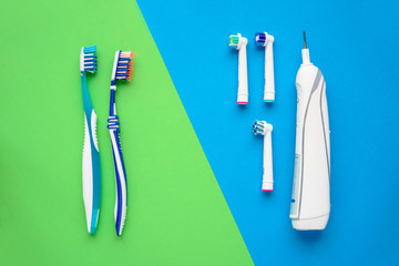 Electric and manual toothbrushes. Top view. Hygiene of the oral cavity. An ordinary toothbrush and electric toothbrush on bright green and blue background.