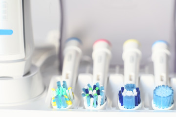 Electric toothbrush and dental hygiene accessories on blurred background
