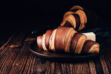 French croissants on a wooden background. Breakfast with tea and coffee.