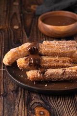 Traditional churros Spanish homemade sweet dessert pastry food on vintage wooden table background.