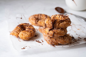 Churros with sugar and chocolate sauce on a white background.