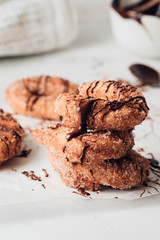 Churros with sugar and chocolate sauce on a white background.