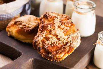 Bread buns, jars with milk on a cutting board 