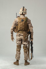 Soldier in camouflage holding rifle