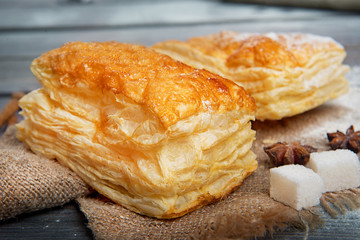Sweet puffs with sugar on a wooden table. Advertising still life from baking.
