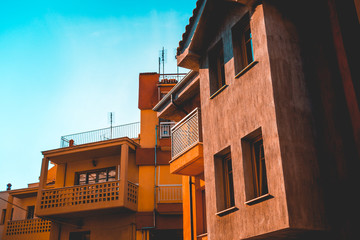 orange colored apartment houses with clean blue sky