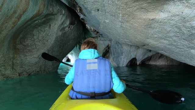 Woman paddles kayak and explores caves named Marble Caves on the lake of General Carrera near the town of Puerto Rio Tranquilo in Patagonia, Chile
