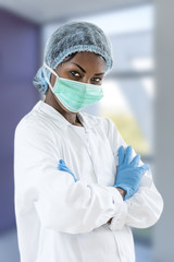 Fototapeta premium portrait of a young woman doctor with a cap and mask and glove, on hospital corridor