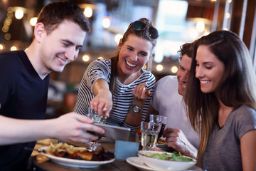 Group Of Friends Enjoying Meal In Restaurant