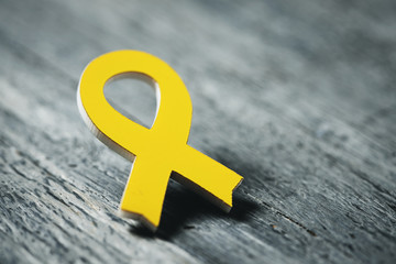 yellow ribbon on a wooden surface - obrazy, fototapety, plakaty