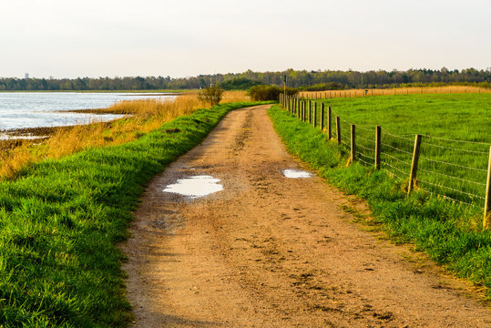 Skanor, Sweden - Country road between the sea and a green field on a morning after a rainy night.