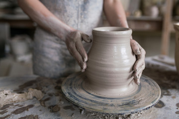 Fototapeta na wymiar potter sculpts a vase on a potter's wheel