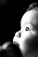 Black and white side portrait of little girl child, closeup face with big eye