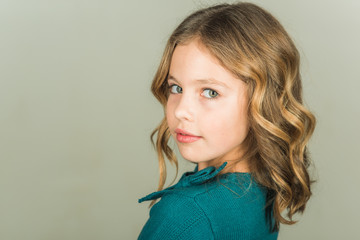 Beautiful little girl model on grey background