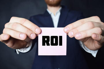 A businessman shows an inscription:ROI