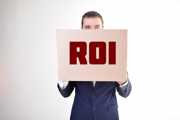 The businessman is holding a box with the inscription:ROI