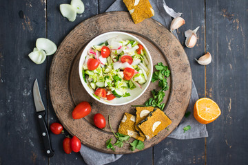 Greek salad with tomatoes, olive oil, cucumber. Mediterranean traditional salad. On wooden board. Raw vegan vegetarian healthy food