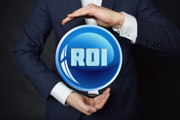 In the hands of a businessman, a neon circle with the inscription:ROI