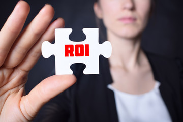 Businessman holding a puzzle with the inscription:ROI