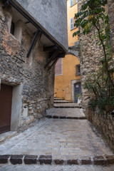 Narrow cobbled street with flowers in the old village Tourrettes-sur-Loup , France.
