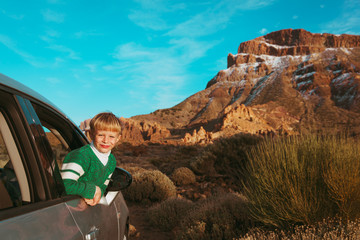Fototapeta premium little boy travel by car on road in mountains