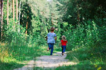 happy little girl and boy run play in nature