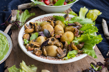 Backed potatoes and roasted mushrooms on salad leaves. Organic farm lunch or dinner. Raw vegan vegetarian healthy food