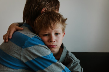 Father comforting sad child, parenting, sorrow