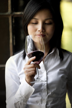 Mid-adult woman holding a glass of red wine.
