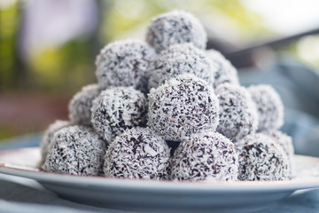 Sweet vegan coconut balls with chocolate, dates, coconut oil, bananas. Indian traditional dessert....
