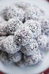 Sweet vegan coconut balls with chocolate, dates, coconut oil, bananas. Indian traditional dessert. Energy bars. Raw vegetarian healthy food