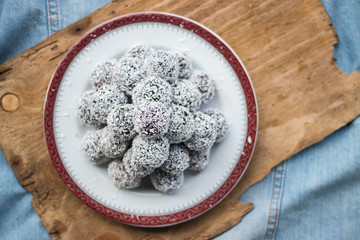 Sweet vegan coconut balls with chocolate, dates, coconut oil, bananas. Indian traditional dessert. Energy bars. Raw vegetarian healthy food