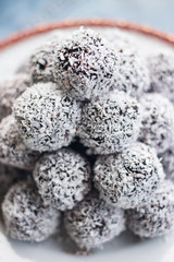 Sweet vegan coconut balls with chocolate, dates, coconut oil, bananas. Indian traditional dessert. Energy bars. Raw vegetarian healthy food