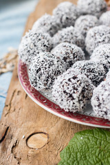 Sweet vegan coconut balls with chocolate, dates, coconut oil, bananas. Indian traditional dessert. Energy bars. Raw vegetarian healthy food