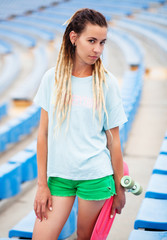 Beautiful young woman with skateboard