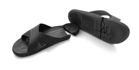 pair of badly worn out slippers on white