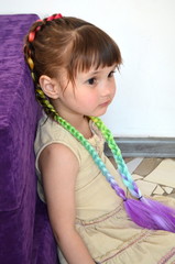 Маленькая красивая девочка с косами с вплетенным канекалоном 