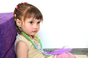 Маленькая красивая девочка с косами с вплетенным канекалоном 