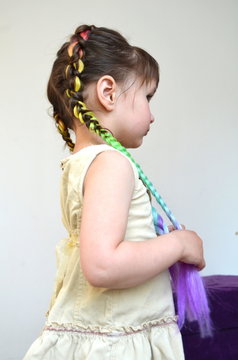 Маленькая красивая девочка с косами с вплетенным канекалоном 