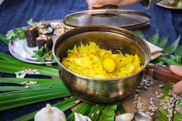 Woman hand holding cooked stewed cabbage with new potato in pot with garlic and turmeric powder. Lunch or dinner time. Traditional Ukrainian and Russian dish. Raw vegan vegetarian healthy food