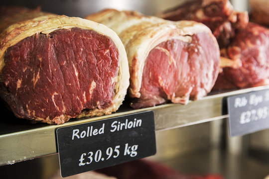 Close Up Of Piece Of Rolled Beef Sirloin Meat On A Metal Shelf In The Chiller At A Traditional Butcher's Shop.