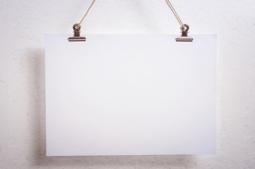 Blank paper poster on white wall background