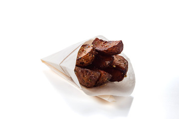 French fries in a gift wrapping on a white background (close)